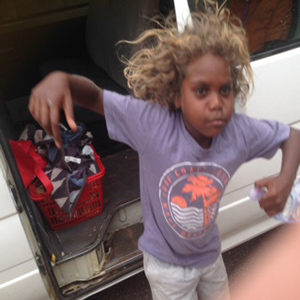 young aborigine girl jumping off her school van