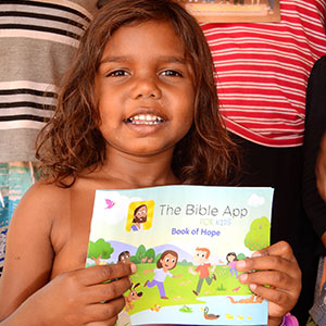 young girl holding bible stories book